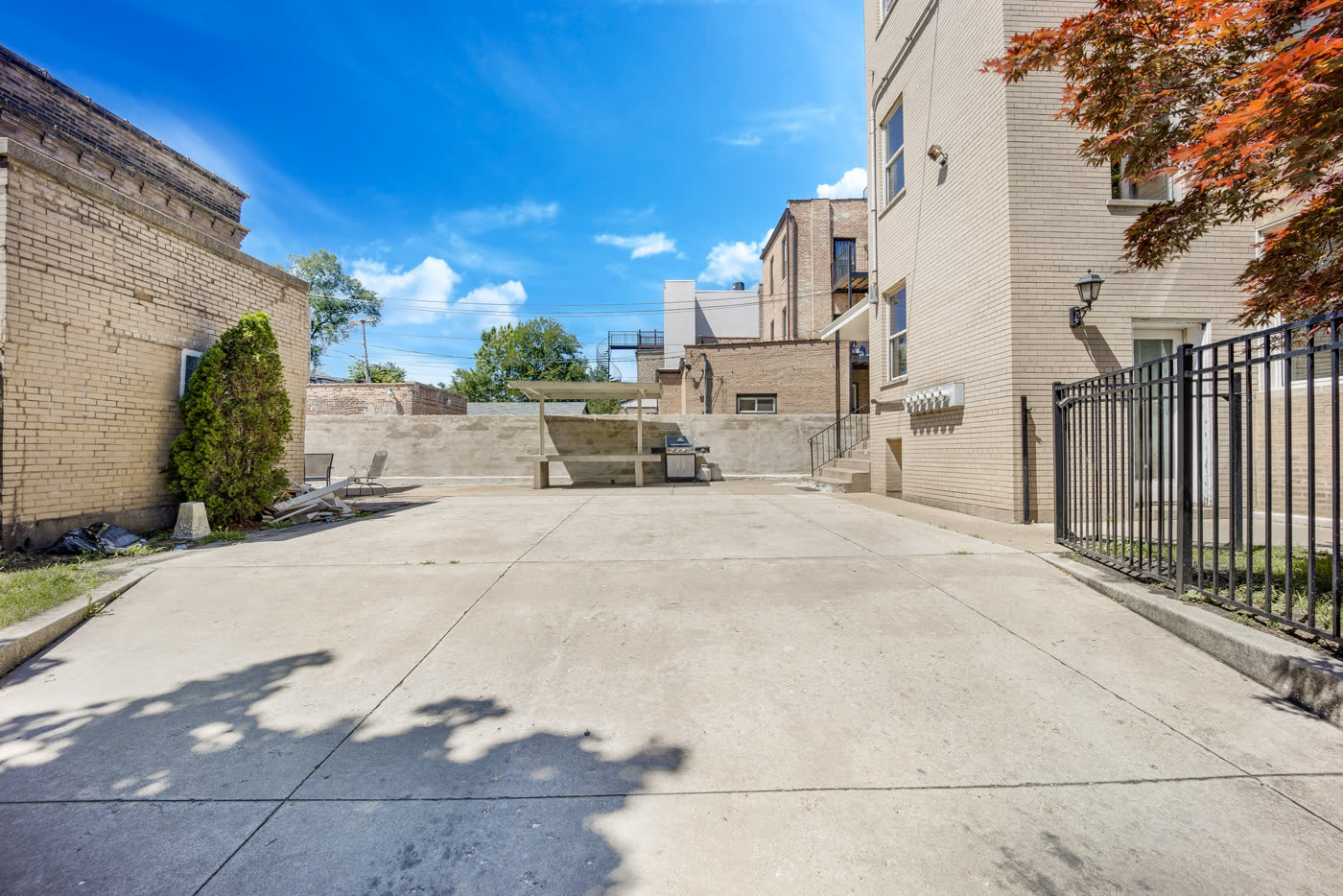 Maintained courtyard and parking at a South Side brick multifamily building.